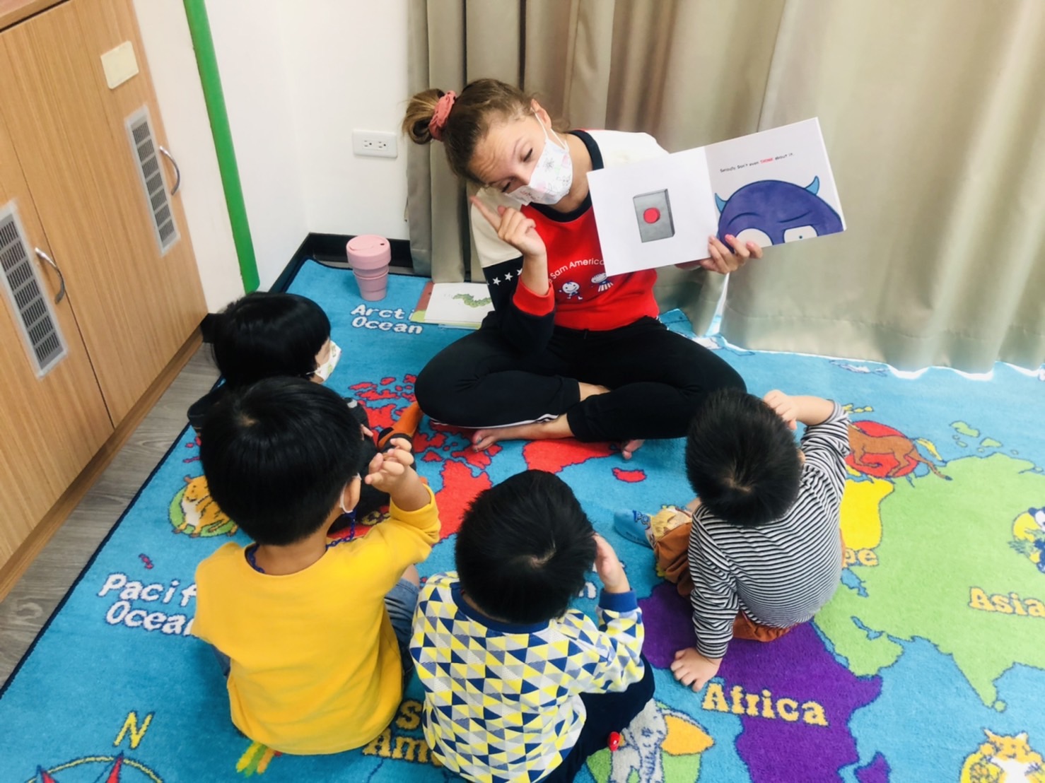 Teacher reading a picture book with a small group of children